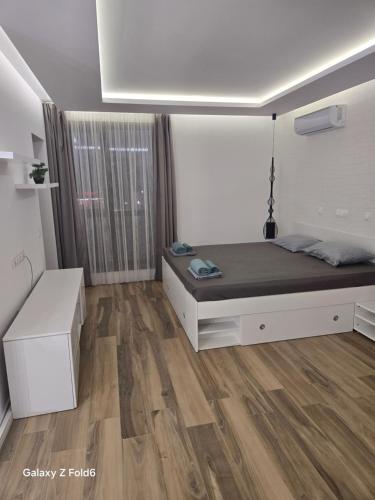 a bedroom with a bed and a wooden floor at Diljanka 4 in Pernik
