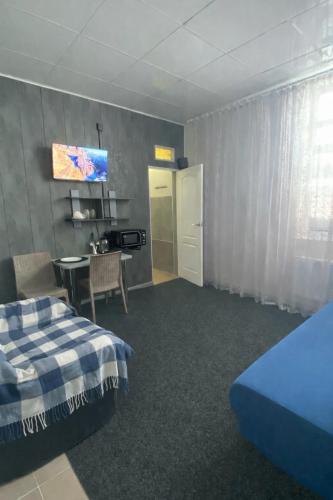 a room with a bed and a table and a tv at МотельХаусSous in Svitlovodsʼk
