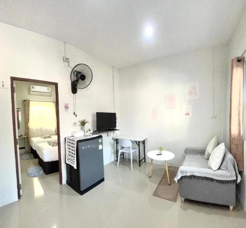 een woonkamer met een bank en een tafel bij Yada House twin bed in Nai Yang Beach