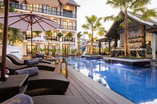 a hotel with a swimming pool and a resort at Narinthra Heritage in Chiang Mai