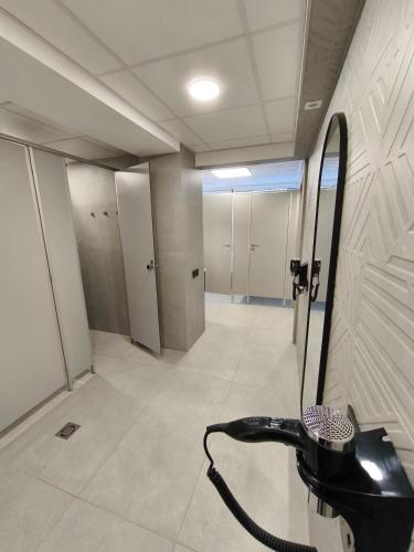 a bathroom with a mirror and a hair dryer at City Center Hostel in Mažeikiai