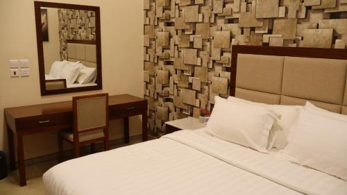 a bedroom with a bed and a desk and a mirror at إقامة البندر 1 - Al Bandar 1 Apartments Managed by Yanbu Suites in Yanbu