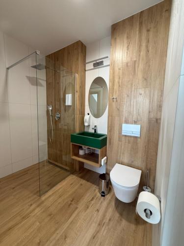 a bathroom with a toilet and a sink and a mirror at Stay at Royal Kraków Golf in Ochmanów