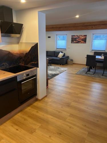 a kitchen and living room with a couch and a table at MyAlpenloft 1 in Deutschgriffen