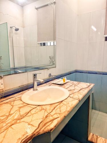 a bathroom with a sink and a mirror at Reina Boutique Hotel - G9 in Islamabad