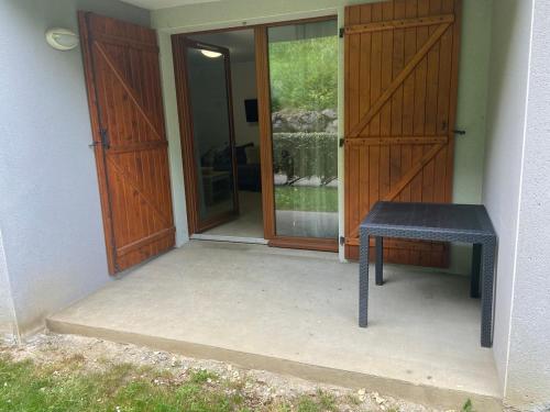 a black bench sitting in front of a door at Appartement 4 couchages in Arreau