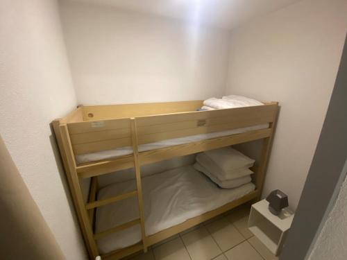 a small closet with a wooden shelf and towels at Appartement 4 couchages in Arreau