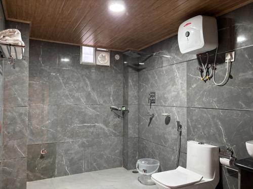 a bathroom with a shower and a toilet at Wisteria Crystal Manor in Pelling