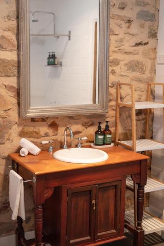 a bathroom with a sink and a mirror at Thedell Cottage - A Boutique Heritage Escape in Auburn