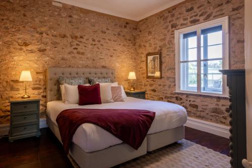 a bedroom with a large bed and a window at Thedell Cottage - A Boutique Heritage Escape in Auburn