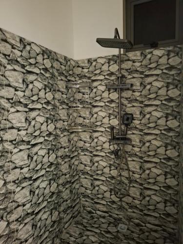 a bathroom with a stone wall with a shower at Salmaan Villa in Grand-Baie
