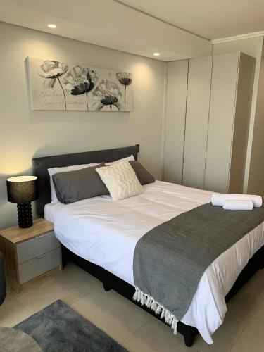 a bedroom with a large bed in a room at Ellipse Luxurious Tamarind Red Studio Experience in Midrand