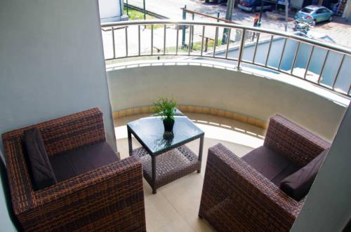 un balcone con 2 sedie, un tavolo e una ringhiera di NO 95 SUITES VI a Lagos