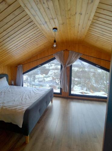 a bedroom with a bed and a large window at Varadeo Hill Resort in Şuncuiuş