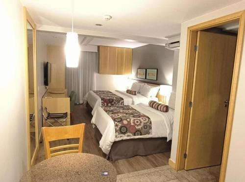 een hotelkamer met twee bedden en een televisie bij RARIDADE!!! - Flat Particular de Alto Padrão - Limpeza Diária Gratuita - Excelente Atendimento - Ótimo Preço - Cama King Size - Dentro do Hotel Lets Idea in Brasilia