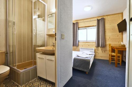 een badkamer met een bed en een wastafel bij Le Balcon des Ecrins in Réallon