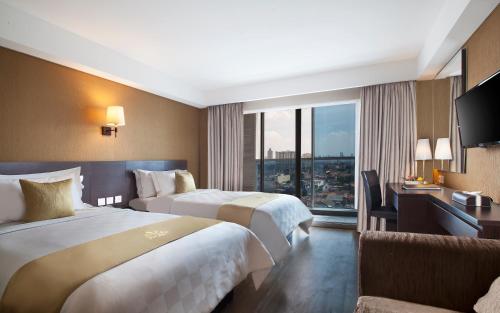a hotel room with two beds and a large window at Best Western Premier The Hive in Jakarta