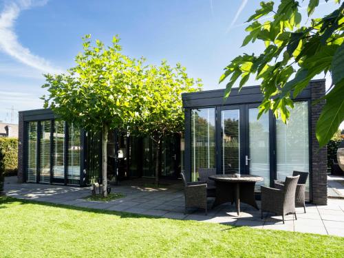 a garden pavilion with a table and chairs at Luxe wellness woning met prive buitensauna in Ermelo