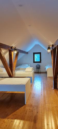 a bedroom with two beds and a tv on the wall at CaSa ViTo Kumrovec in Brezje