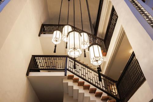 an image of a staircase with chandeliers at Narinthra Heritage in Chiang Mai