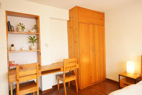 una camera da letto con una scrivania, un armadio e un letto di Dwell Casa a Patan