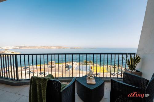 a balcony with a view of the ocean at A Stylish Seaside Holiday Home in St Paul's Bay in St. Paul's Bay