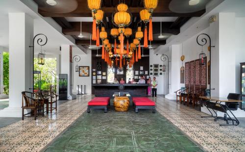 a lobby of a hotel with chairs and tables at The Old Phuket - Karon Beach Resort in Karon Beach