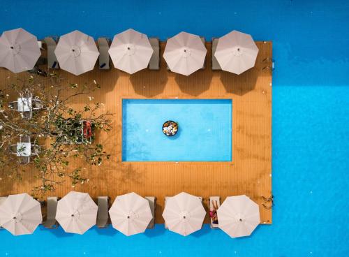an overhead view of a pool with white umbrellas at The Old Phuket - Karon Beach Resort in Karon Beach