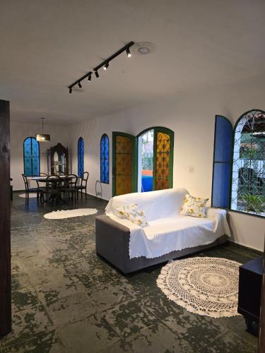 a bedroom with a bed in a room with stained glass windows at Refúgio da Zena in Mairiporã