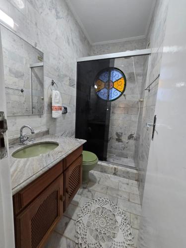 a bathroom with a sink and a shower with a window at Refúgio da Zena in Mairiporã
