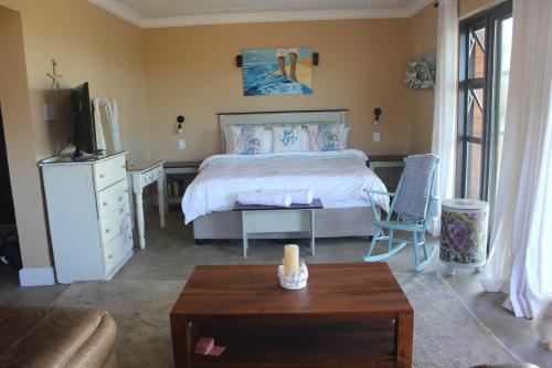 una camera da letto con un letto, una tv e un tavolo di Seas the Breeze Romantic cottage for 2 a Boknes