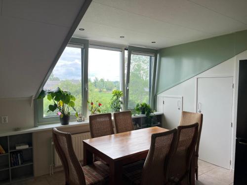 a dining room with a table and chairs and windows at Boerderij Hazenveld in Kockengen