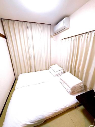 a small room with a bed and a window at クオリティハイツ101号室 in Tokyo