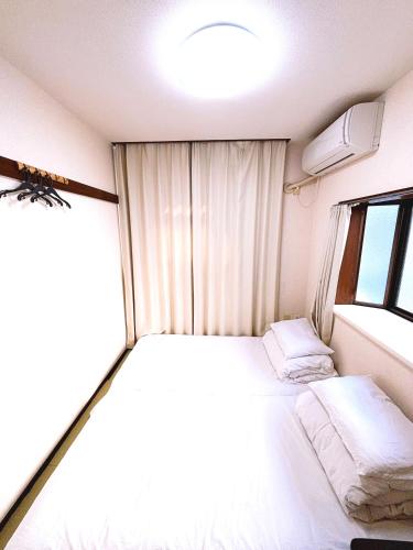 a small room with a bed and a window at クオリティハイツ101号室 in Tokyo