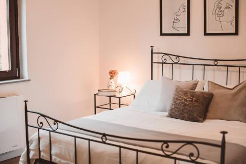 una camera da letto con un letto con lenzuola e cuscini bianchi di Villa bif nel verde tra BobbioGrazzano1h Milano a Viserano