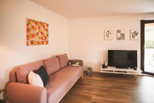 un soggiorno con divano e TV a schermo piatto di Villa bif nel verde tra BobbioGrazzano1h Milano a Viserano