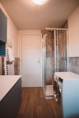 a bathroom with a walk in shower and a washer at Villa bif. nel verde tra Bobbio/Grazzano/1h Milano in Viserano