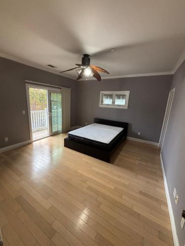 a bedroom with a bed and a ceiling fan at Private room private balcony shared bathroom - Mini Mansion in Burbank