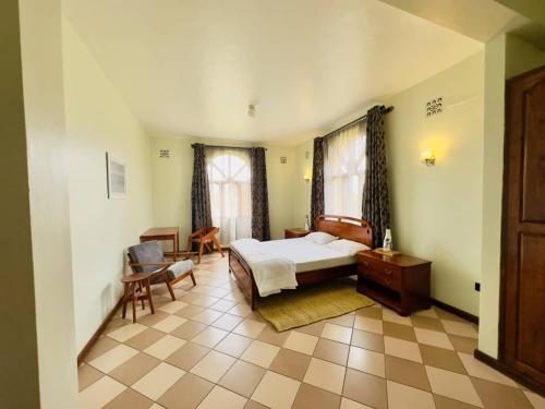 a bedroom with a bed and a desk and a chair at Starehe Villa in Arusha