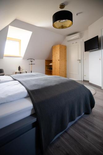 a bedroom with a bed with a blanket on it at Strommer wine das Gästehaus in Purbach am Neusiedlersee
