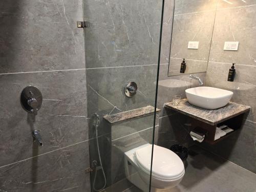 a bathroom with a toilet and a sink at Nyotel-MP Nagar Bhopal in Bhopal