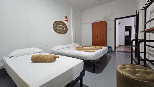 a room with two beds and a chair at Three Elements Mirissa in Mirissa