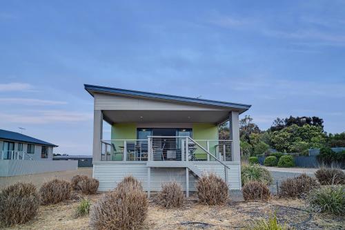 a small house with a balcony on a beach at Long Island Retreat - Pelican in Murray Bridge