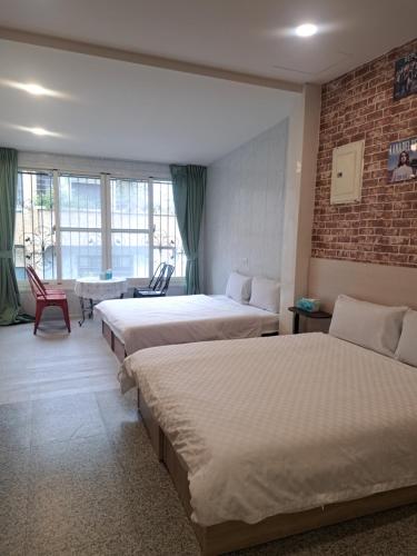a hotel room with two beds and a table and chairs at House of love in Xiaoliuqiu