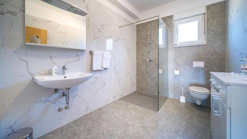a bathroom with a sink and a shower and a toilet at Villa Cyprian by Villas Guide in Kampor