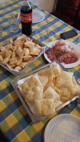 a table with plates of food and a bottle of soda at Agriturismo Boschi in Reggiolo