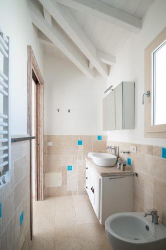a white bathroom with a sink and a toilet at Villa Ca' La Luna by Klodge in Budoni