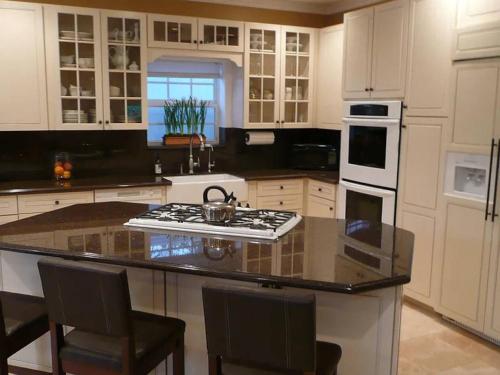 a kitchen with white cabinets and a stove top oven at Private room private balcony shared bathroom - Mini Mansion in Burbank