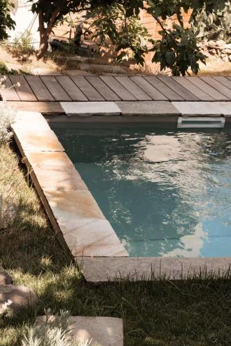a small pool of water next to a wooden deck at Montera appartement centre ville avec piscine chauffée et jardin in Bastia