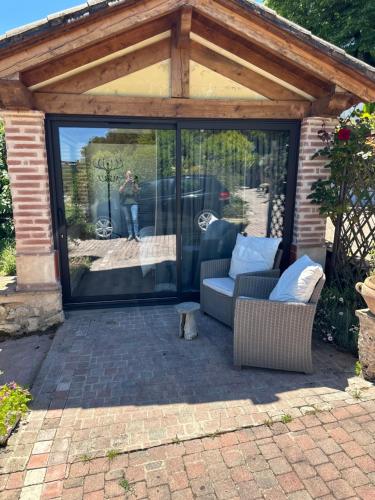 a screened in patio with two chairs and a table at Le clos des Oiseaux in Itzac